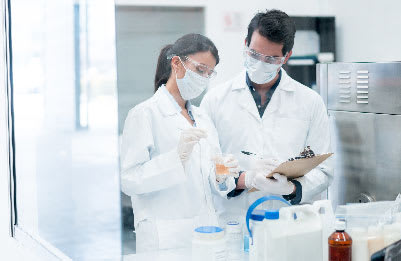 Two lab safety managers in a lab discussing and documenting an experiment