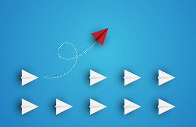 A group of lab leaders standing around a conference table reviewing documents for business management